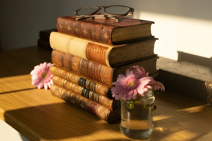 a stack of books sitting on top of a wooden table